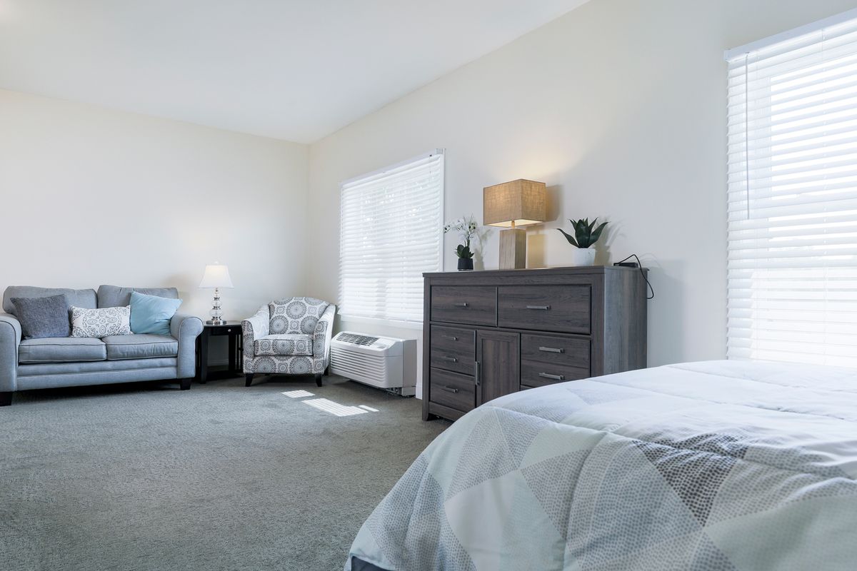 A bright and spacious bedroom with modern furniture and decor.