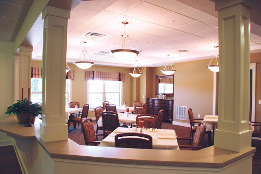 A well-lit dining area featuring multiple tables and chairs, designed for a comfortable dining experience.
