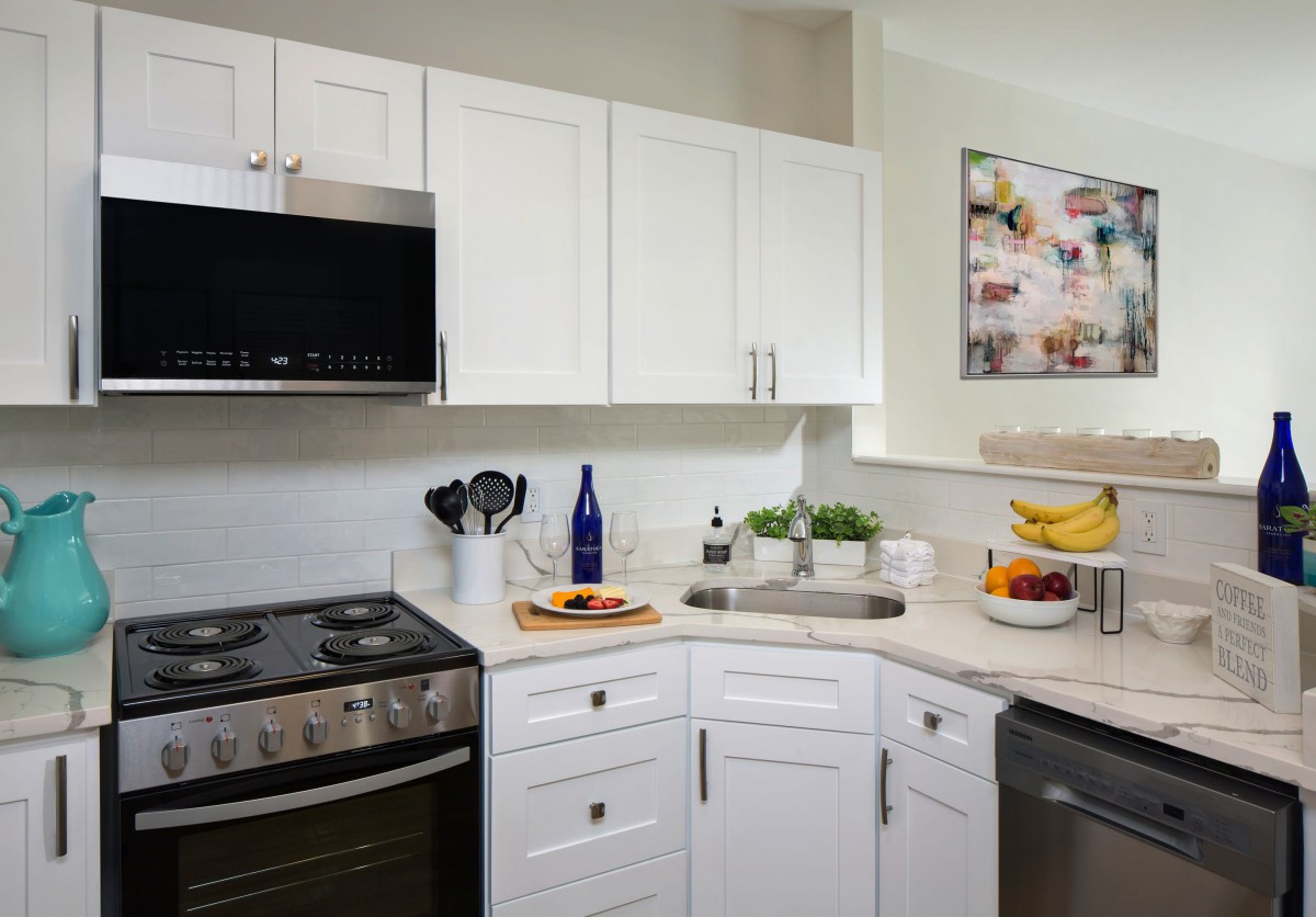 Modern kitchen interior with white cabinets and stainless steel appliances.