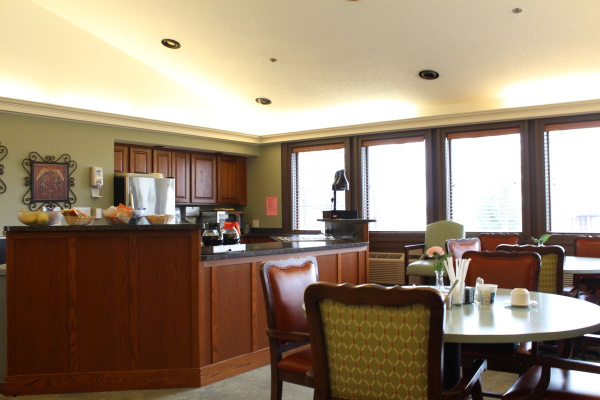A cozy kitchen and dining area with wooden cabinets and a coffee station.