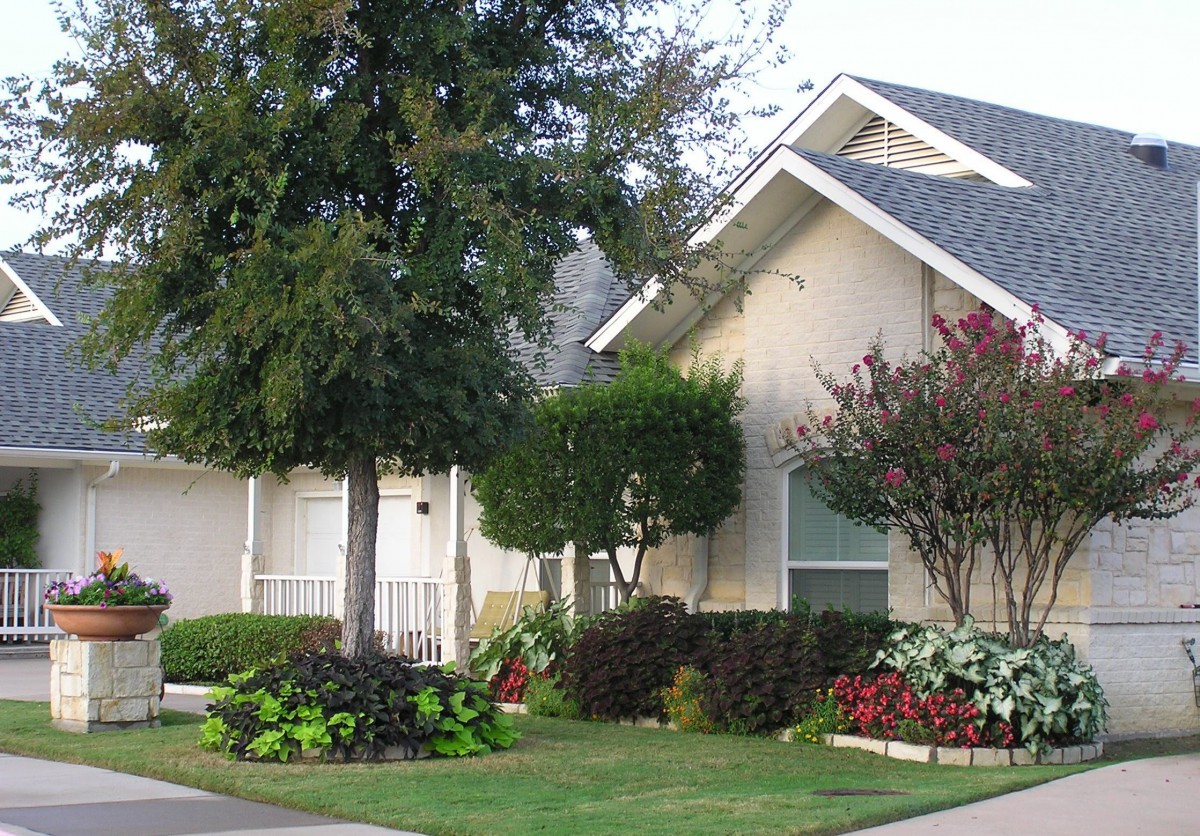A suburban house with well-maintained landscaping and a lush front yard.