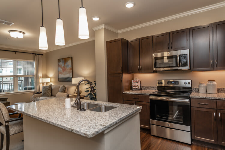 A modern kitchen with granite countertops and stainless steel appliances.