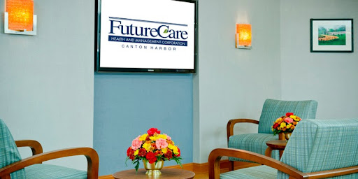 A modern healthcare waiting room featuring the FutureCare logo displayed on a television, complemented by floral decor.