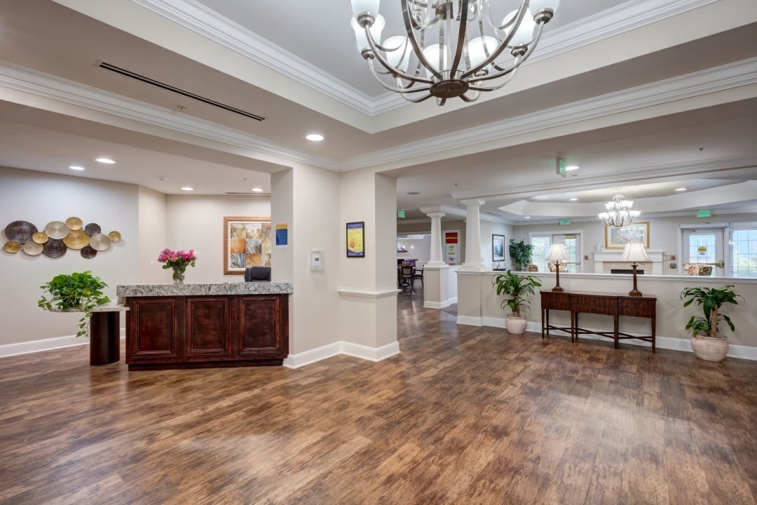 Elegant lobby area with a chandelier and wooden flooring.