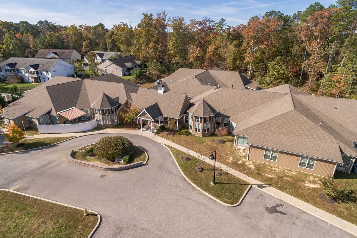Aerial view of a residential building surrounded by trees in autumn.