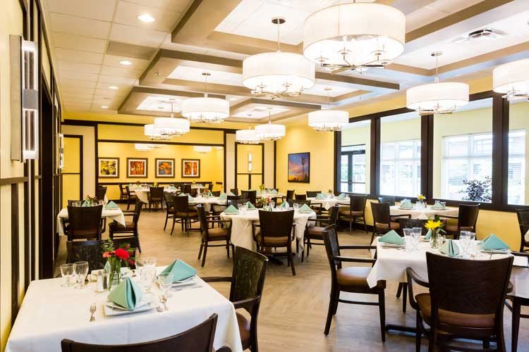 A well-lit restaurant dining area with elegantly set tables and modern decor.