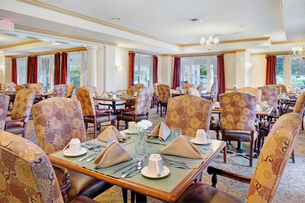 An elegantly set dining room with tables and chairs arranged for guests.