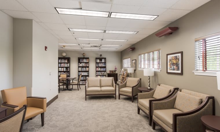 A well-lit waiting room with comfortable seating and bookshelves.