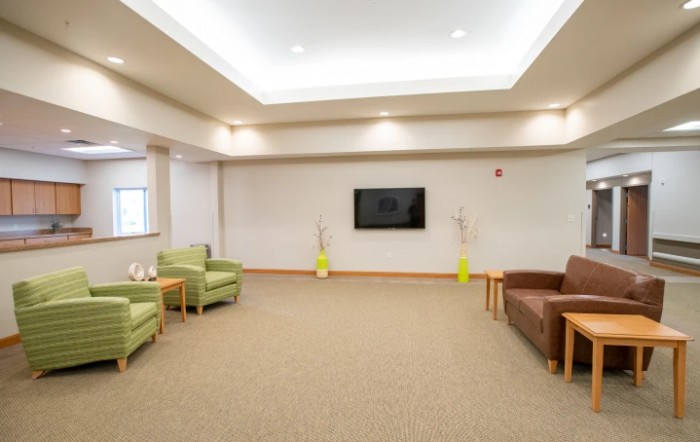 A modern lobby with comfortable seating and a wall-mounted TV.