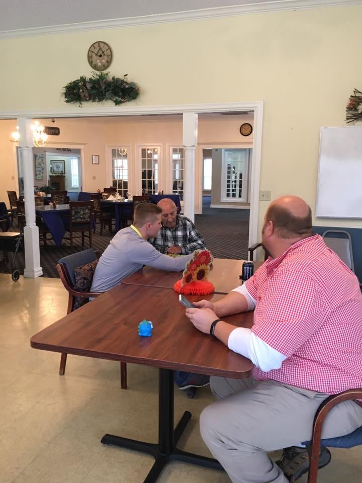 A group of people having a conversation in a casual indoor setting around a table.