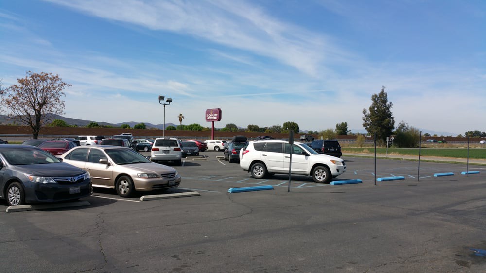 A parking lot with several cars parked under a clear blue sky.