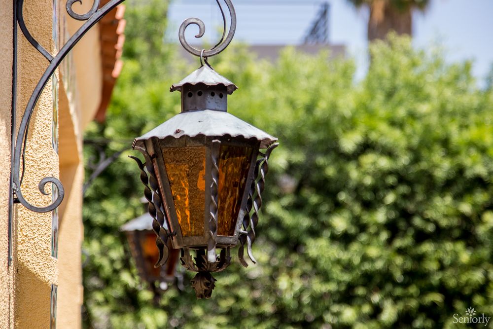 A vintage metal lantern hangs in a garden setting.