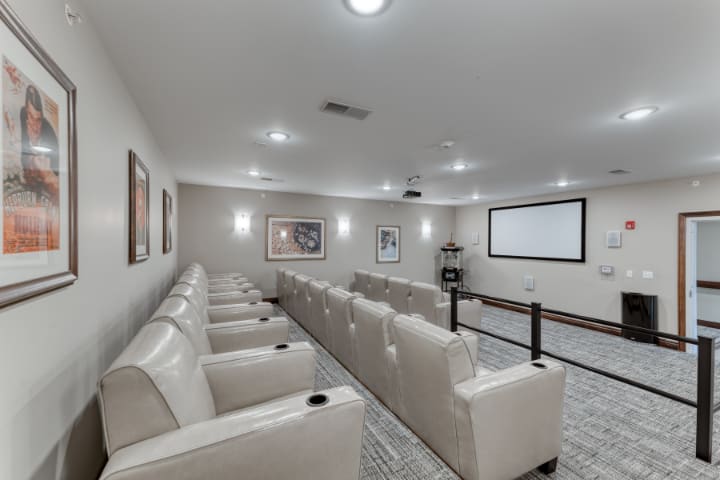 A modern home theater room with comfortable seating and a large screen.