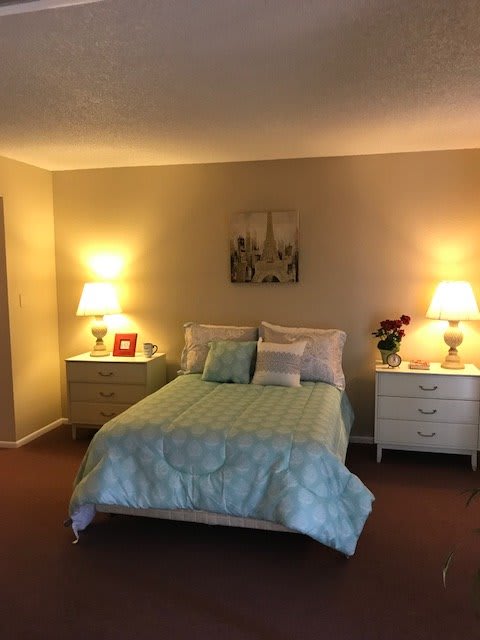 A cozy bedroom with a double bed, flanked by two illuminated nightstands.