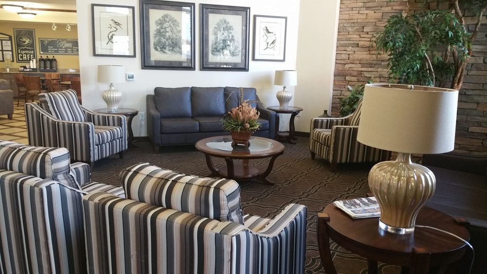 A cozy living room with striped chairs, a sofa, and artwork on the walls.