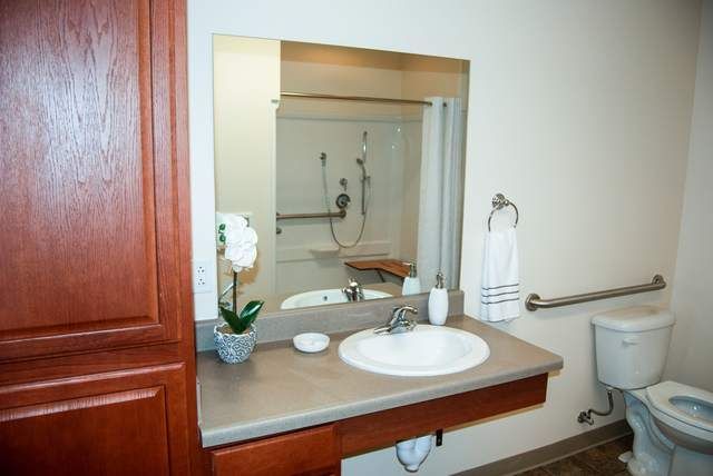 A bathroom vanity with a sink, mirror, and accessories.