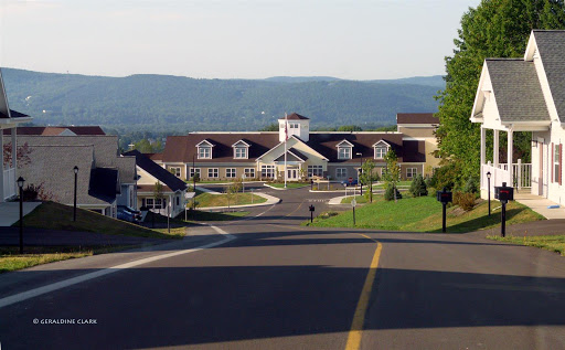 A scenic view of a residential building nestled among rolling hills.