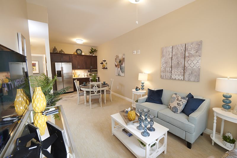 A modern open-concept living space featuring a cozy living room, dining area, and kitchen.