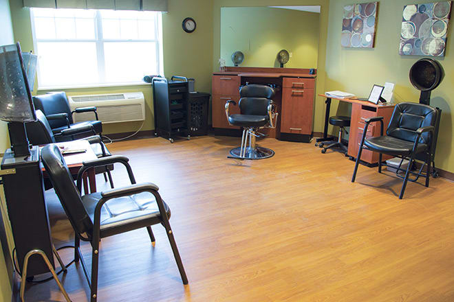 An empty barbershop interior with chairs and a stylist station.