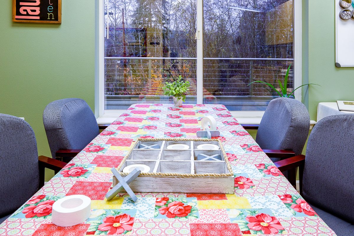A cozy dining area with a floral tablecloth and a view of the garden.