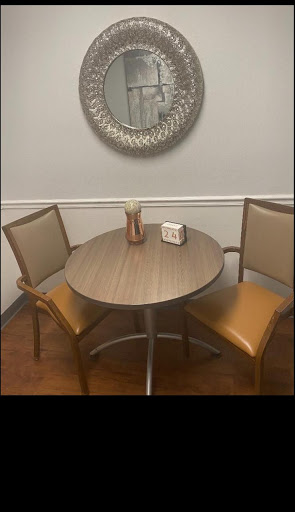 A cozy dining setup featuring a round wooden table and two chairs.