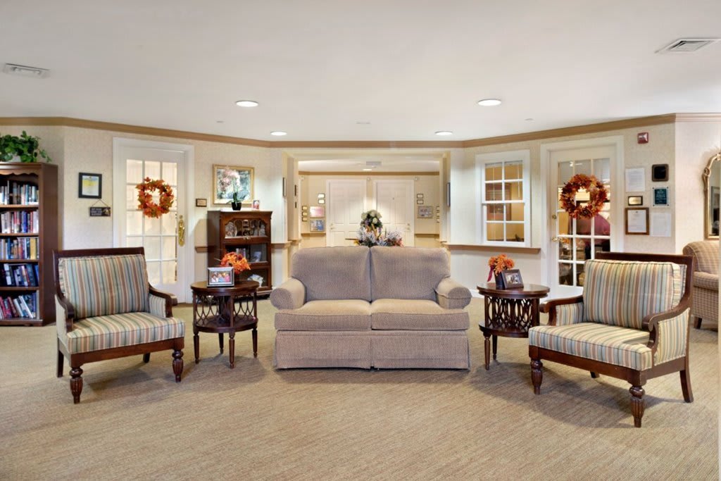 A cozy living room with a sofa, chairs, and decorative elements.