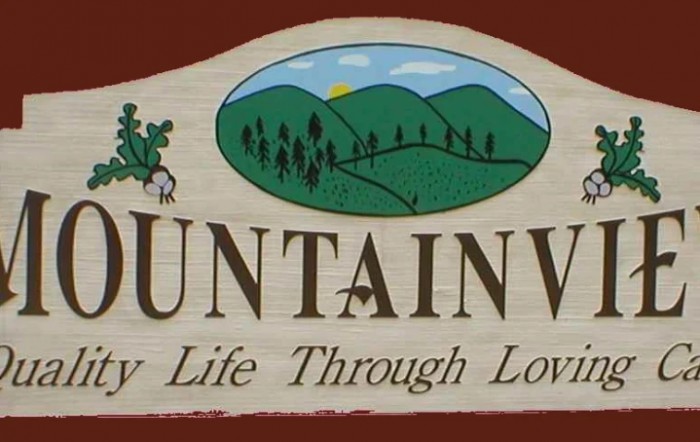 A sign displaying an illustration of mountains with a slogan beneath.