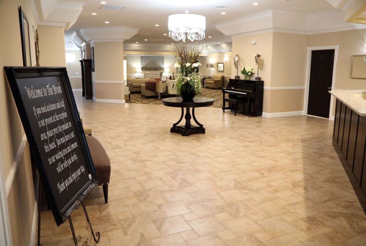 Spacious and elegantly decorated lobby with a central table and chandelier.