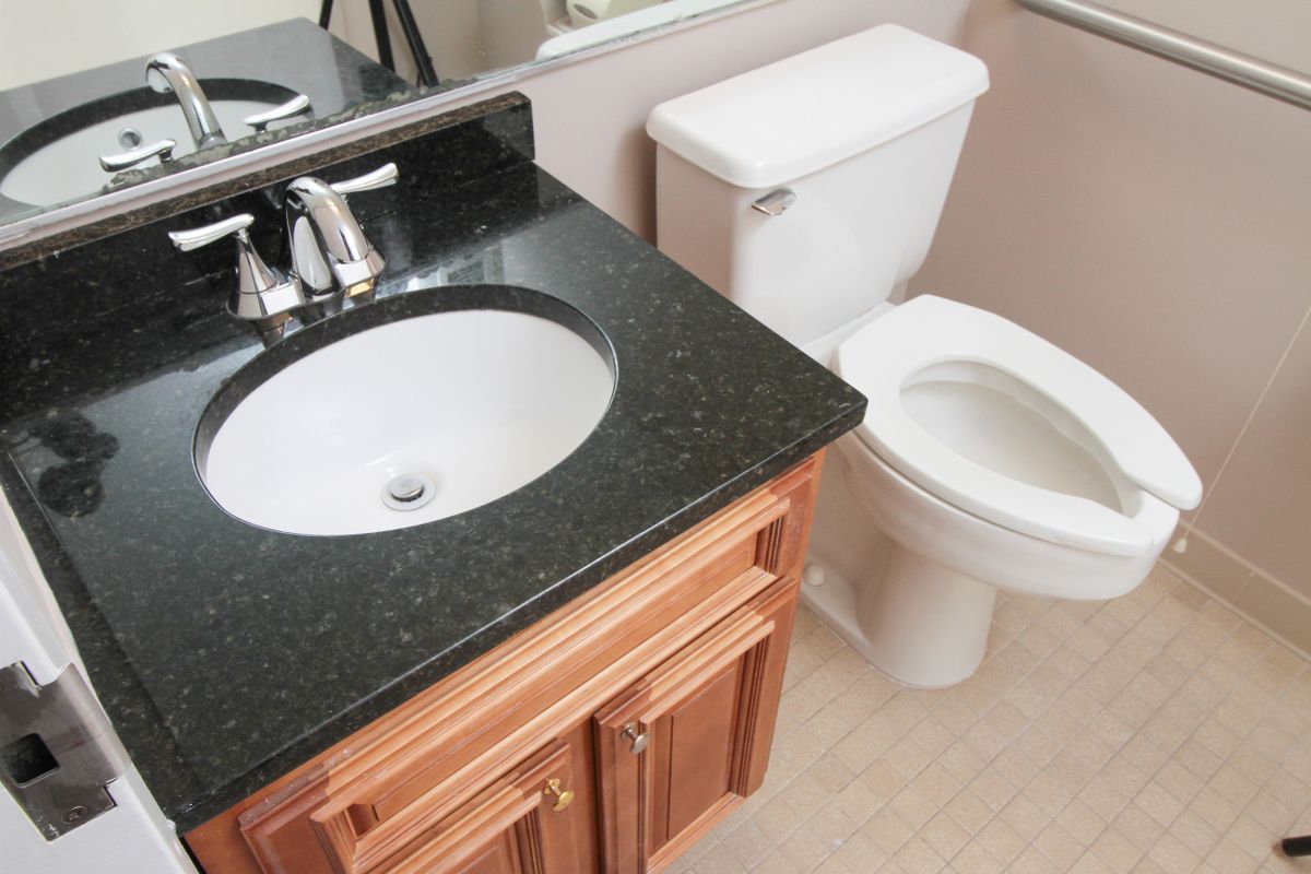 A clean and modern bathroom with a sink, vanity, and toilet.