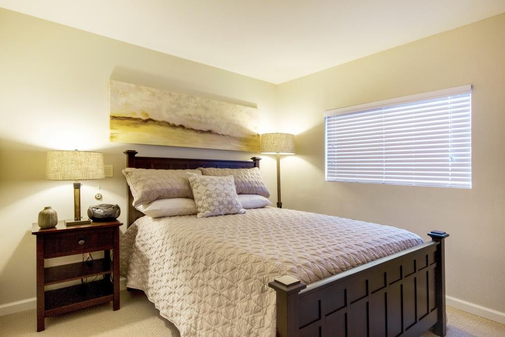 A cozy bedroom with a neatly made bed, side tables, and soft lighting.