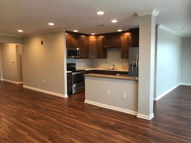 A modern kitchen with an open floor plan and hardwood flooring.