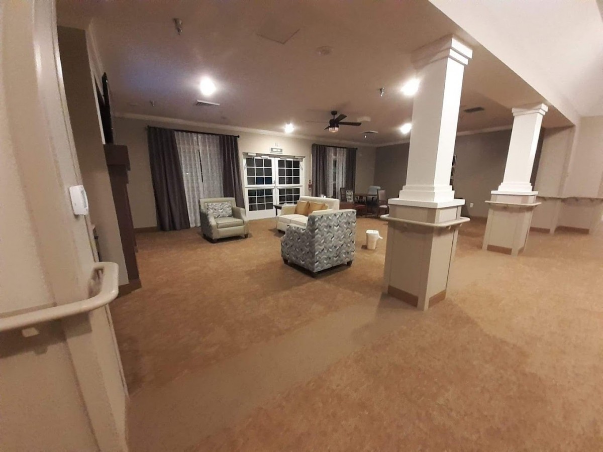 A spacious living room with comfortable seating and elegant pillars.