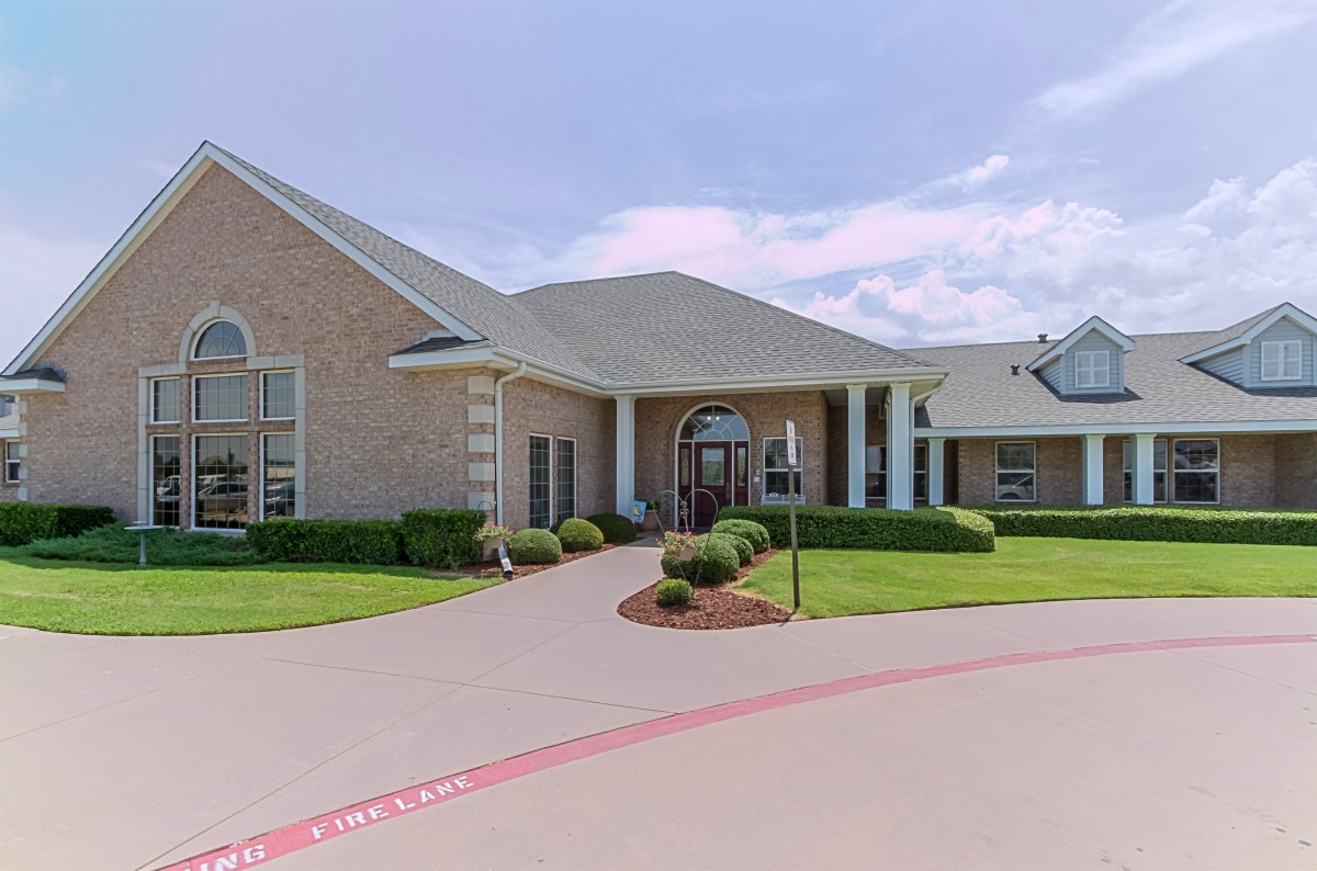 A suburban residential building with a well-maintained driveway and landscaping.