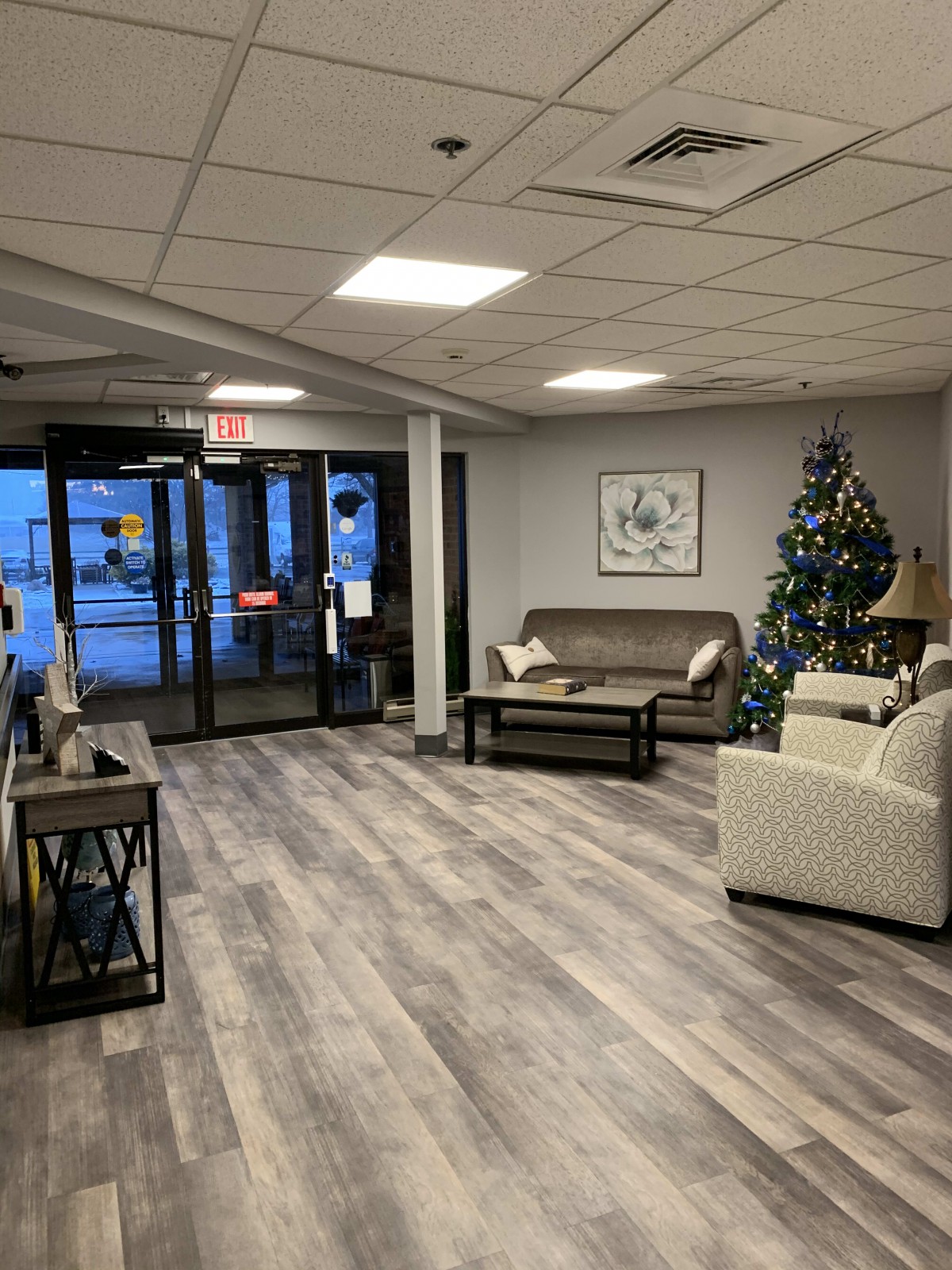 A cozy lobby with comfortable seating and a decorated Christmas tree.