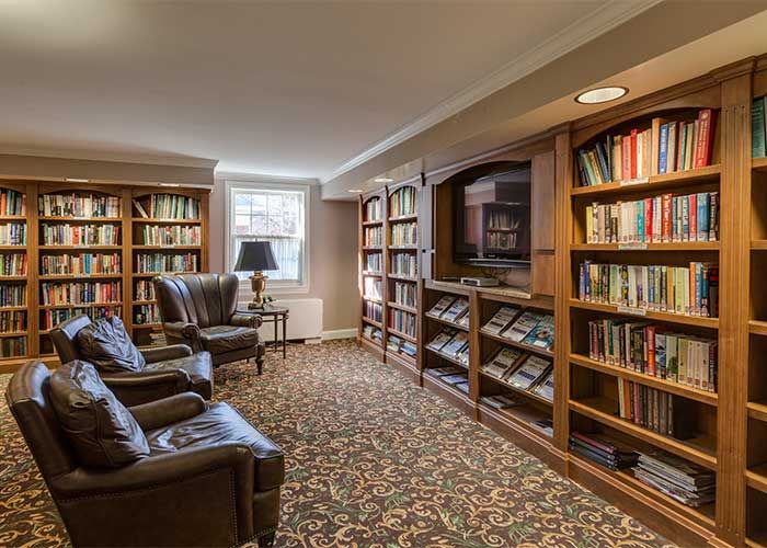 A cozy library corner with armchairs and bookshelves.