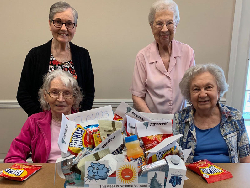 A group of elderly women enjoying snacks together indoors.