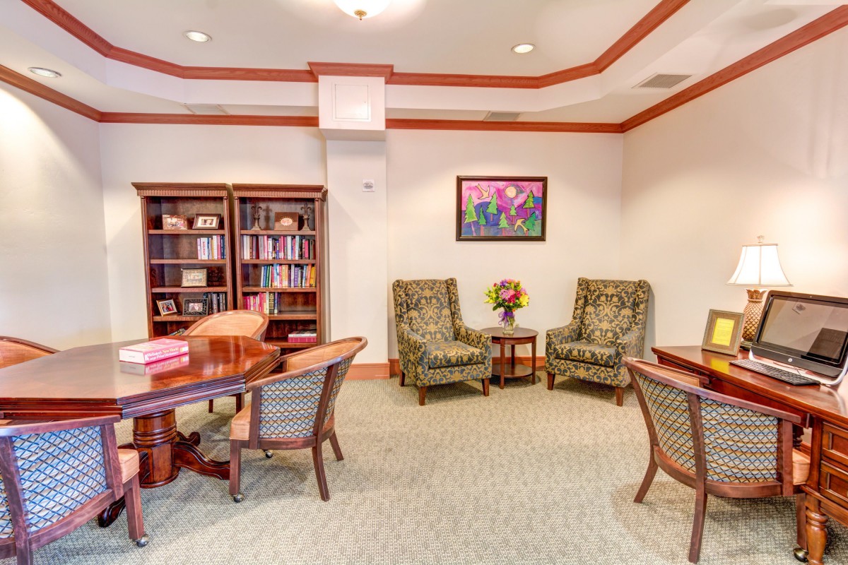 A cozy office space with bookshelves, a desk, and comfortable seating.