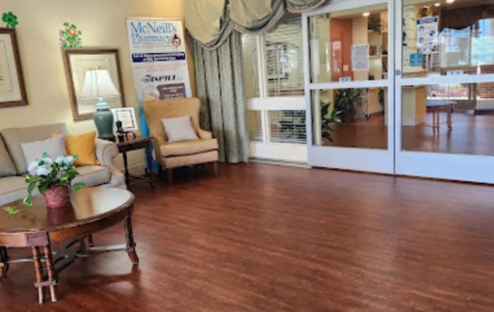 A cozy lobby area with comfortable seating and hardwood floors leading to a glass entrance.