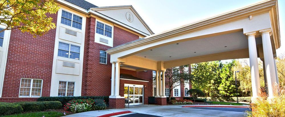 A building entrance with a covered driveway and brick exterior.