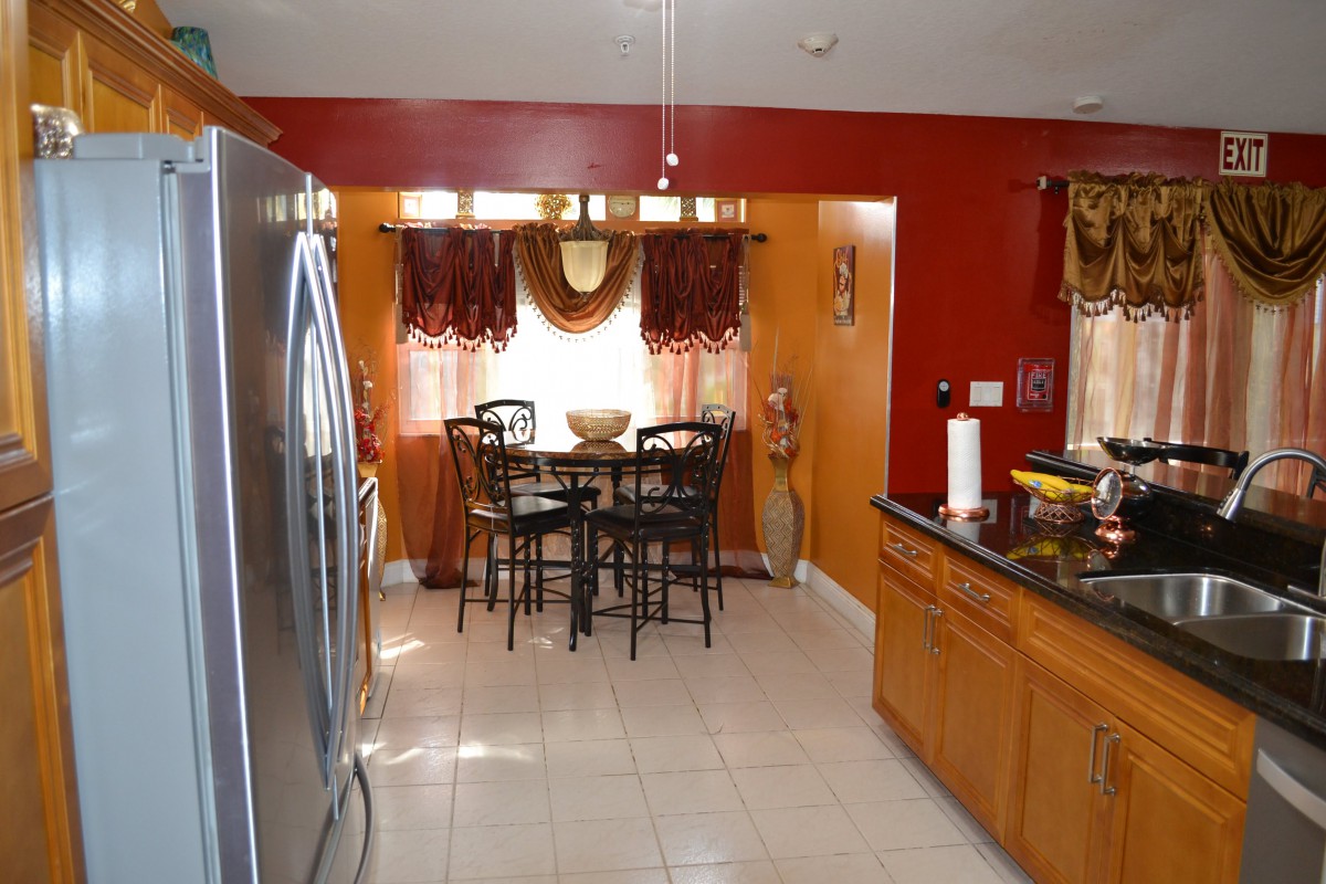 A cozy kitchen with wooden cabinets, modern appliances, and an adjoining dining area.