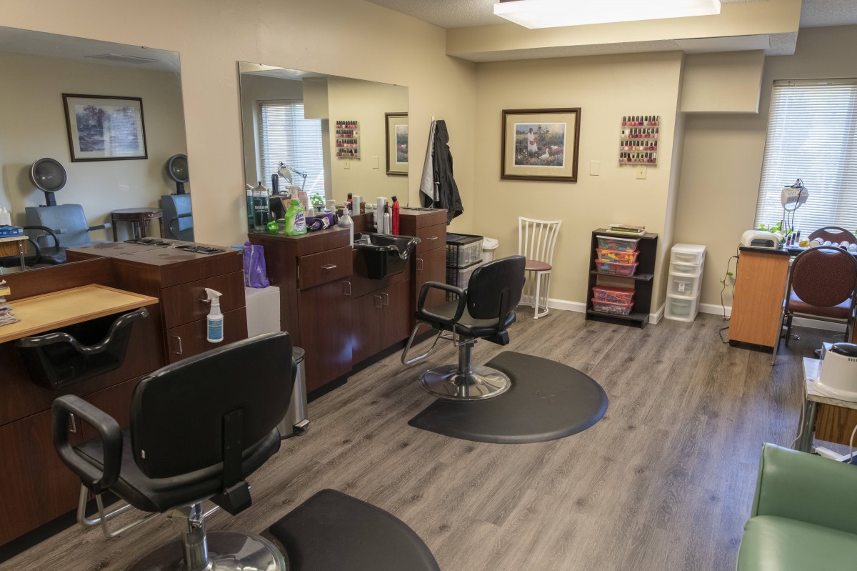 An interior view of a hair salon featuring styling chairs, mirrors, and various salon equipment.