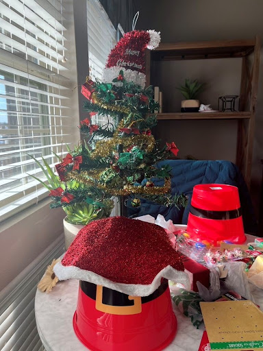 A cozy corner decorated for Christmas with a mini tree and Santa hats.