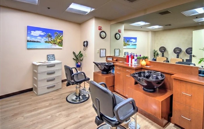 A cozy and well-organized hair salon interior with styling chairs, mirrors, and a hair wash station.