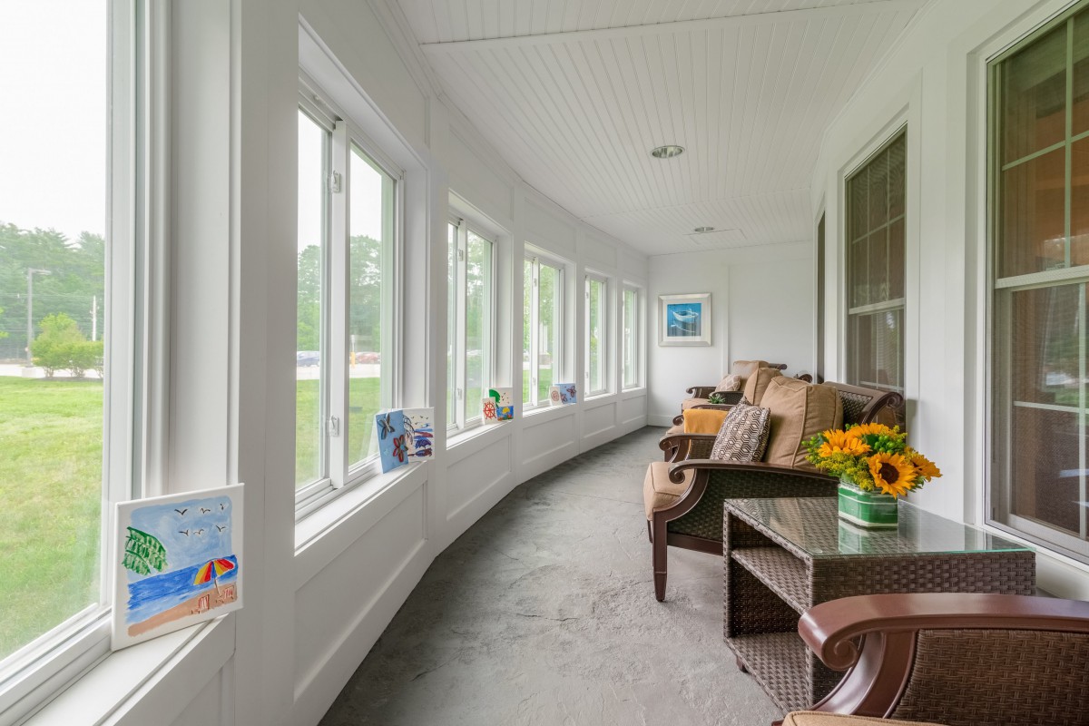 A bright and inviting sunroom with large windows and comfortable seating.