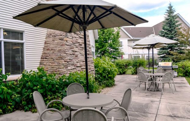 A cozy outdoor patio area with tables and chairs under large umbrellas.