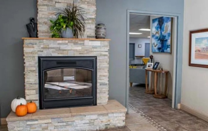 A modern living room featuring a stone fireplace and stylish decor.