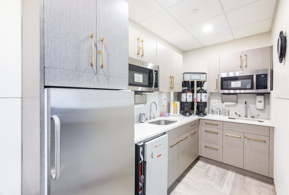 A modern kitchen with stainless steel appliances and bright lighting.