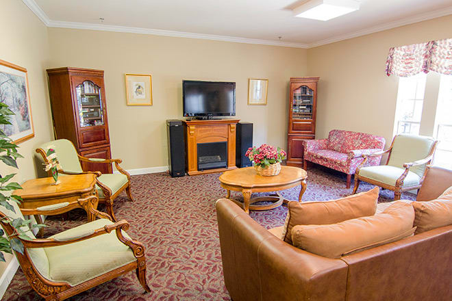 A cozy living room with sofas, a television, and a fireplace.