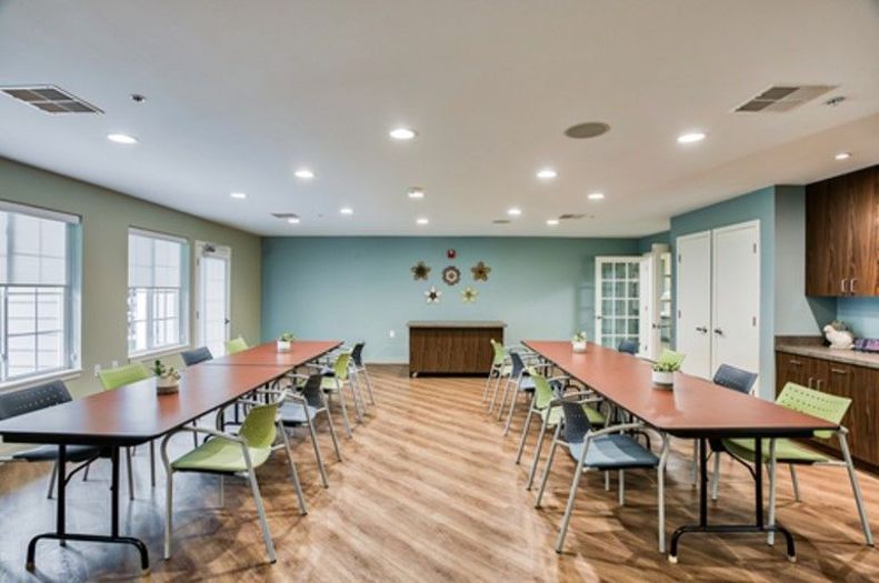 A spacious conference room with long tables and chairs set up for a meeting.
