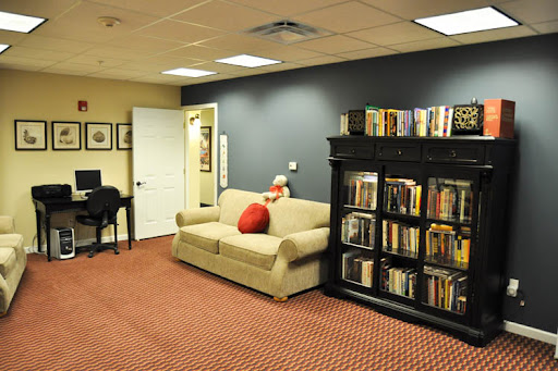 A cozy living room with a comfortable sofa, a bookshelf filled with books, and warm decor.